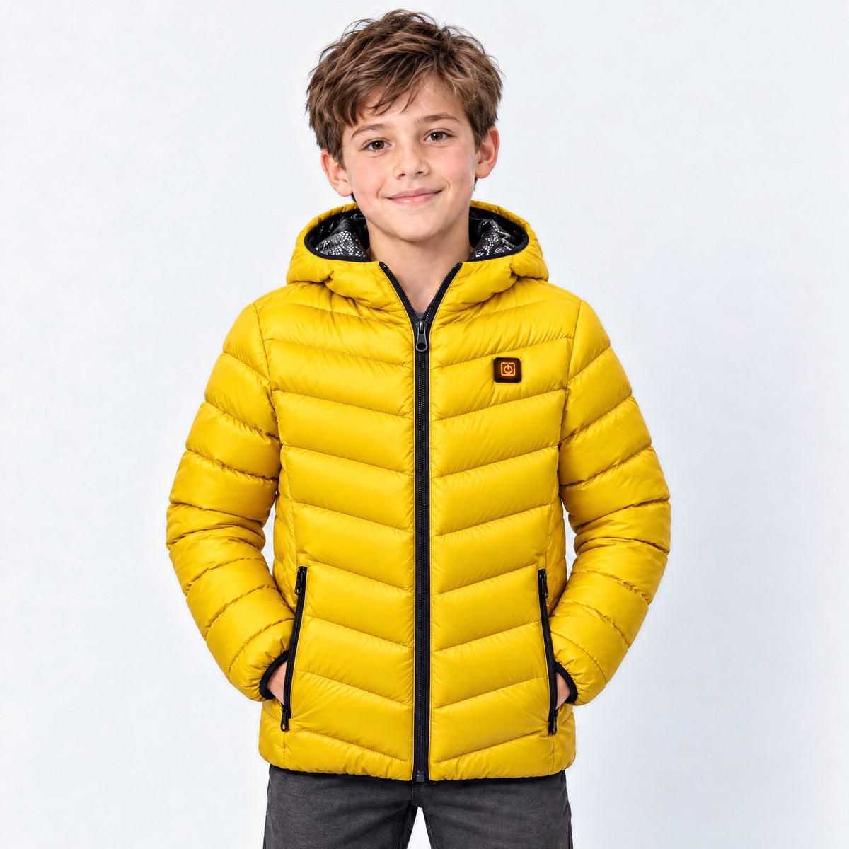 Doudoune chauffante enfant Alpine jaune portée par un garçon, photo studio sur fond clair
